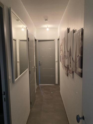 un couloir avec une porte et des peintures sur les murs dans l'établissement Deux chambres dans appartement de 96m2, à Angers
