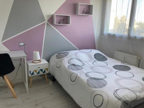une petite chambre avec un lit et un bureau dans l'établissement Deux chambres dans appartement de 96m2, à Angers
