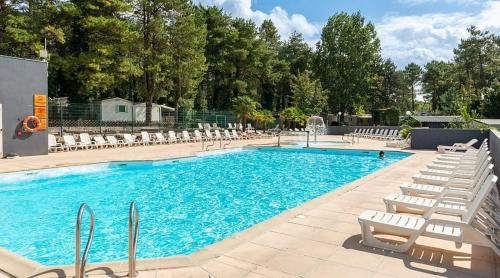 une piscine avec des chaises longues et une piscine dans l'établissement La CABANE d'Arthur, à Camiers