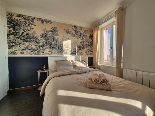 une chambre avec un grand lit avec des serviettes dessus dans l'établissement 50m2 vue sur le château, à Montbéliard