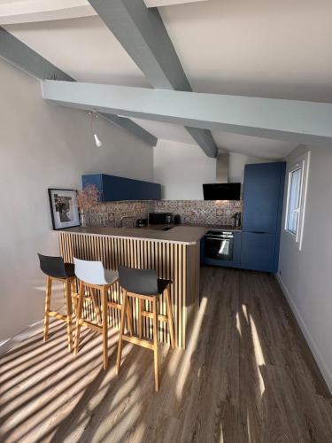 une cuisine avec une table et des chaises dans une pièce dans l'établissement Vue mer - Appartement 7 personnes, à Saintes-Maries-de-la-Mer
