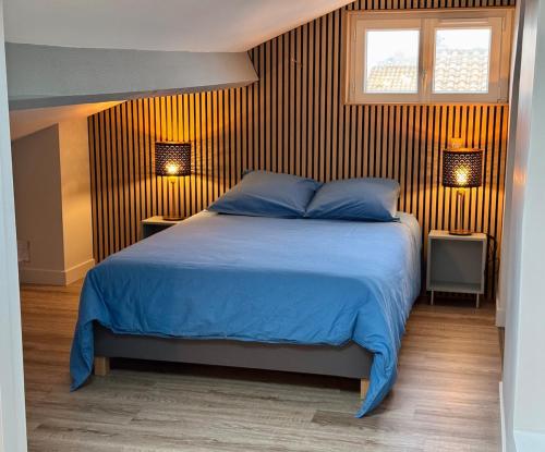- une chambre avec un lit avec des draps bleus et deux lampes dans l'établissement Vue mer - Appartement 7 personnes, à Saintes-Maries-de-la-Mer