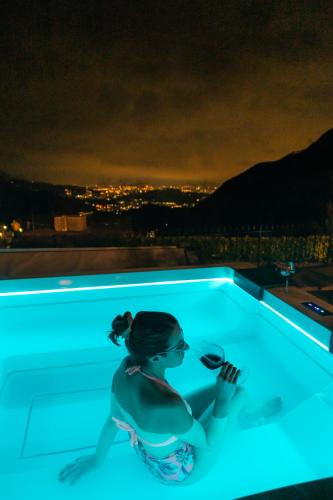 a woman sitting in a swimming pool at night at Ca' Baetti l'Antica Corte in Roncola