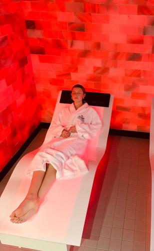 a man laying on a bed in a room with red walls at Le Chateau Des Thermes in Chaudfontaine
