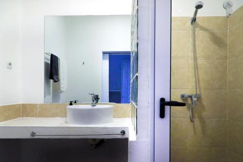 a bathroom with a sink and a shower at Casa das Palmeiras - Palm Tree House in Ponta do Ouro