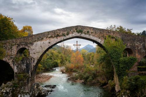 an old stone bridge over a river with a cross at APARTAMENTOS CASA FREDI - Apartamento la novena in Cardes