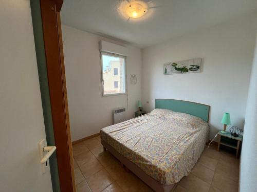 une petite chambre avec un lit et une fenêtre dans l'établissement Leg pavillon, à Valras-Plage