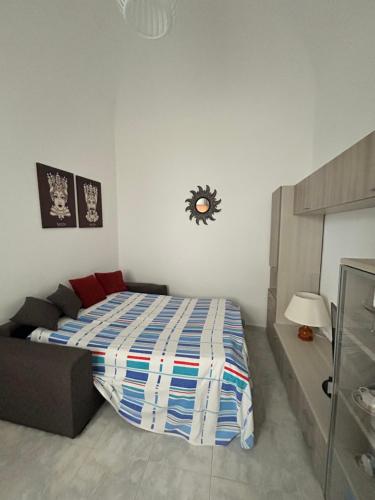 sypialnia z łóżkiem, kanapą i zegarem w obiekcie Casa vacanza da Paola w Trapani