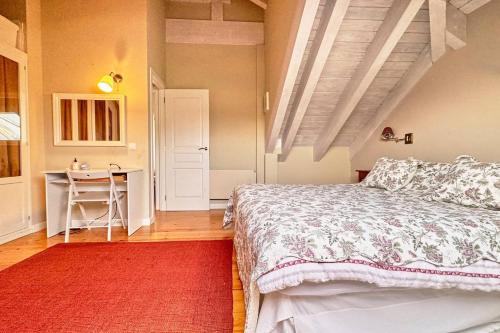 a bedroom with a bed with a red rug and a table at Lblab11A La Brana in San Vicente de la Barquera
