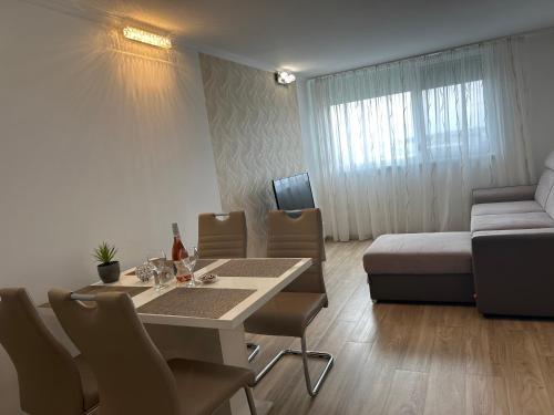 a living room with a table and a couch at Silver Apartman in Siófok