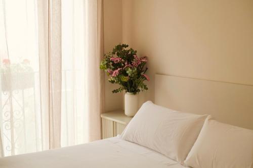 Bett mit einem weißen Kissen und einer Topfpflanze in der Unterkunft CASA SIRFANTAS Málaga in Málaga