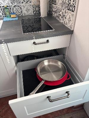 a kitchen with a sink and a pan in a drawer at Strandhaus in der Düne in Dierhagen