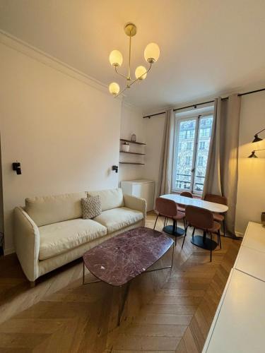 un salon avec un canapé et une table dans l'établissement Central Apartment Tronchet 1G, à Paris