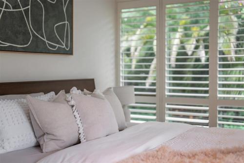 a bedroom with a bed with white pillows and a window at Calla Vale - 3 Bed House Incredible Valley Views in Kangaroo Valley