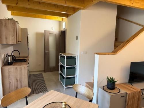 a living room with a table and a kitchen at Náš sen - Domek in Svratouch