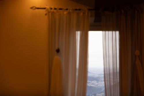 a window with a white curtain in a room at Ca' Baetti l'Antica Corte in Roncola