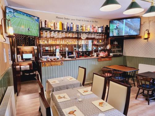 a restaurant with two tables and a bar at Roy Bridge Hotel in Fort William