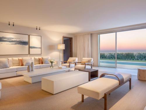 a living room with white furniture and a large window at Fairmont La Hacienda Costa del Sol in Alcaidesa