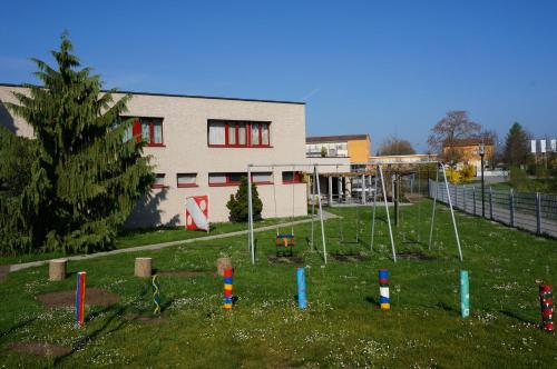 a building with a yard with playground equipment in front of it at Jugendherberge Romanshorn in Romanshorn
