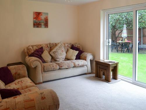 ein Wohnzimmer mit Sofa und Tisch in der Unterkunft Hideaway Cottage in Kingsgate