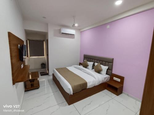 a bedroom with a bed and a tv in it at Hotel Akruti Inn in Anand
