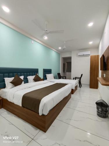 a bedroom with two large beds in a room at Hotel Akruti Inn in Anand