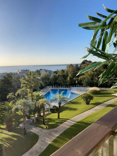une vue d'un complexe avec piscine et palmiers dans l'établissement CANNES EDEN résidence 