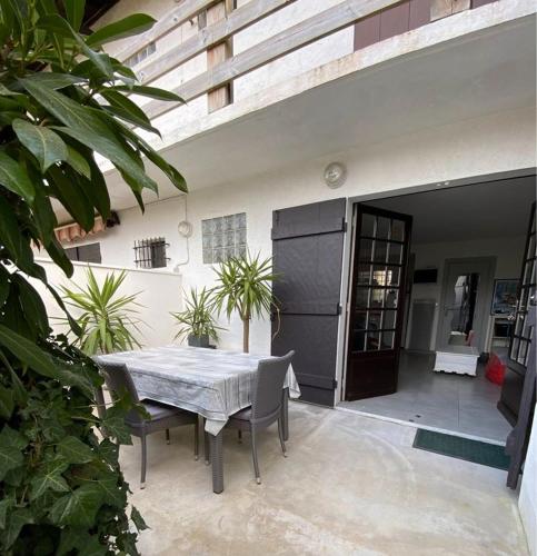 un patio avec une table et des chaises devant un bâtiment dans l'établissement Studio lumineux avec terrasse, à Arcachon