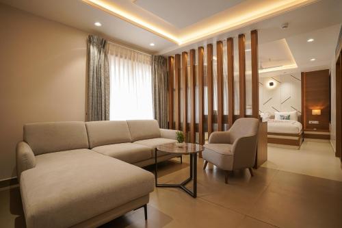 a living room with a couch and a chair and a bed at TreeHouse Kambers in Belgaum