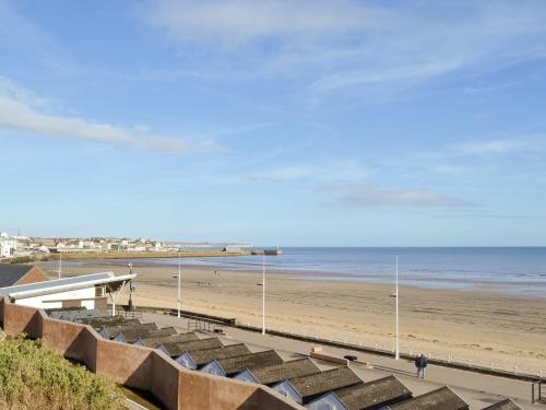 a view of a beach with a pier and the ocean at Memory Lane in Flamborough