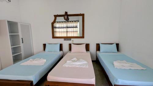 a room with two beds and a mirror at Skyy Villa matara in Matara