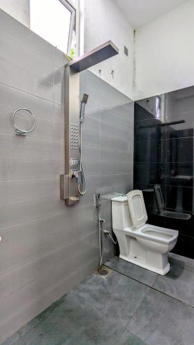 a bathroom with a toilet and a phone on the wall at Skyy Villa matara in Matara
