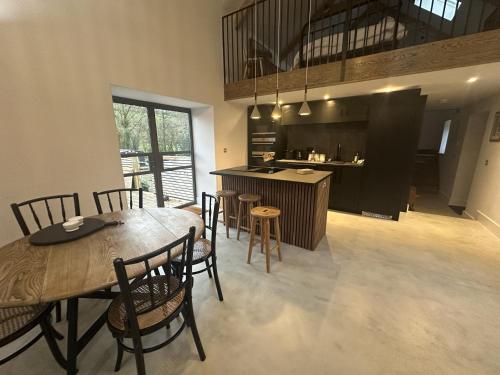 a kitchen and dining room with a table and chairs at Beudy at Pentrecelyn - a gorgeous barn conversion with hot tub in Carmarthen