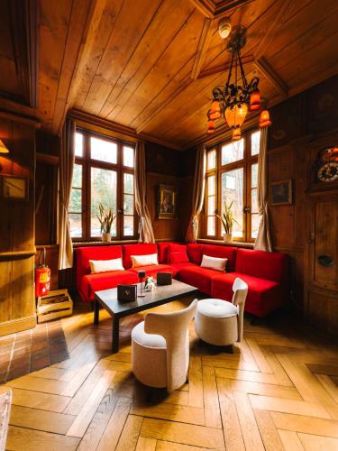 a living room with red couches and a table at Les Violettes Hotel & Spa in Jungholtz