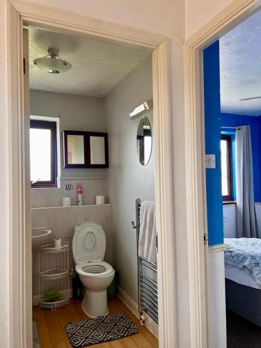 a bathroom with a toilet and a sink and a bed at Bull Double bed in shared house in Stifford