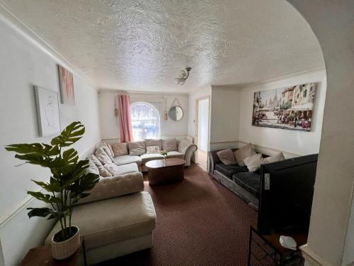 a living room with a couch and a tv at Bull Double bed in shared house in Stifford