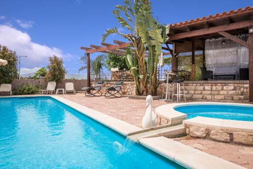 a swimming pool with a swan next to a house at Areti Suites in Kathiana