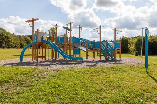 une aire de jeux avec un toboggan dans un parc dans l'établissement Camping Paradis Vallée du Lot, à Pujols