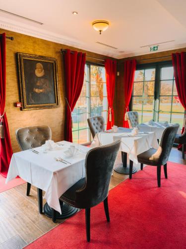 a dining room with tables and chairs and red carpet at Les Violettes Hotel & Spa in Jungholtz