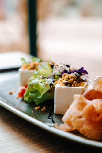 a plate of food with cheese and broccoli on a table at Les Violettes Hotel & Spa in Jungholtz