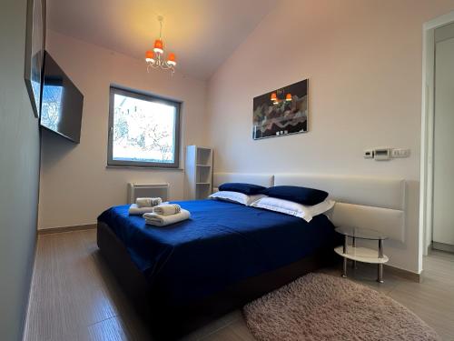 a bedroom with a blue bed and a window at Wellness Villa Biocrystal with heated indoor pool, private spa, tennis court and fitness in Hreljin