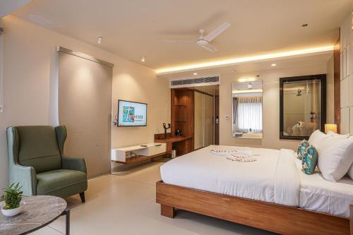 a bedroom with a bed and a chair in a room at TreeHouse Kambers in Belgaum