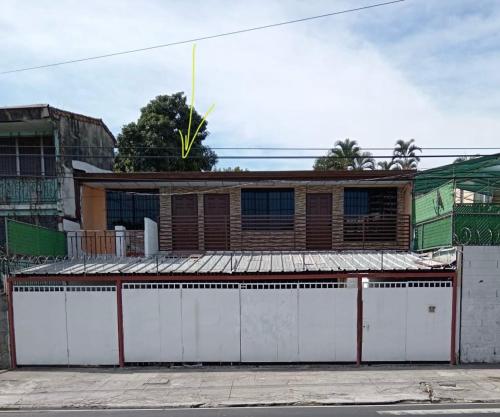 a building with two white doors and a fence at Luxury Hostel Teresita in San Salvador