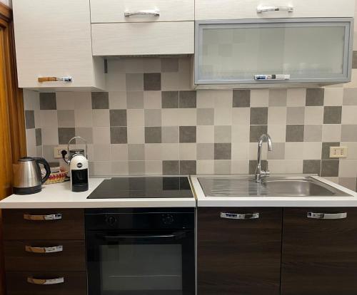 a kitchen with a sink and a stove top oven at Casa Melly in Barletta