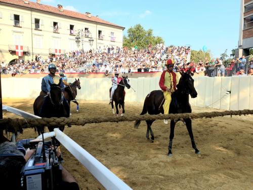 two people riding horses in front of a crowd at Appartamento Mi & Ti in CastellʼAlfero