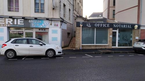 une voiture blanche garée sur le côté d'une rue dans l'établissement Le Carré Bleu - Studio Confort - Centre-ville, à Dieppe