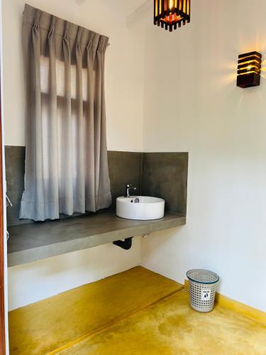 a bathroom with a sink and a window at Villa 66 Ahangama in Ahangama
