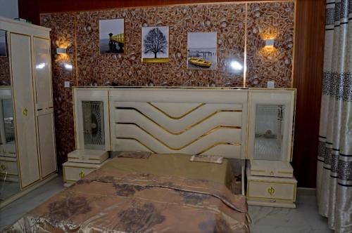 a bedroom with a bed and a wall with pictures at Résidence CHEZ TIMERA in Keur Massar