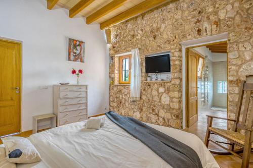 a bedroom with a large bed and a stone wall at Fora Vila in Manacor