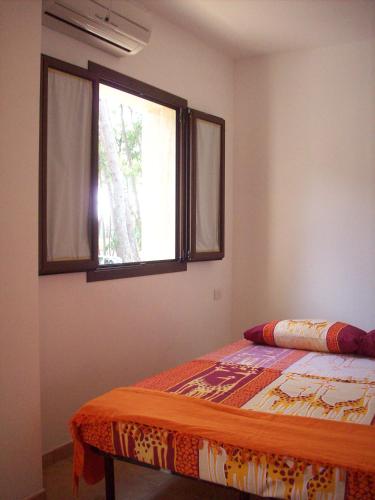 a bedroom with a bed and a window at Villaggio Camping Bosco Selva in Alberobello
